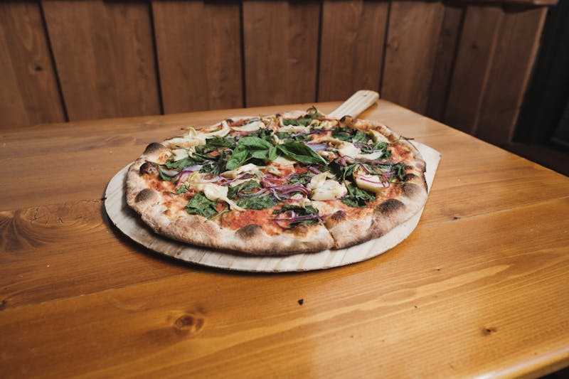 White spinach thin crust pizza with garlic cream sauce